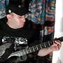 A bass guitar player mellows out in the hotel room.